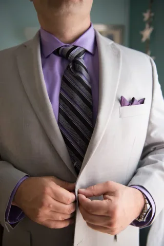 Groom adjusting suit jacket